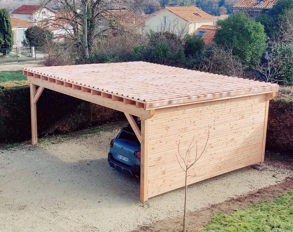 Abri voiture bois moderne avec toit imitation tuile, soutenu par des poteaux et un mur latéral en planches. SUV garé sur une allée en gravier.